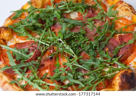 Pizza with meat and green arugula