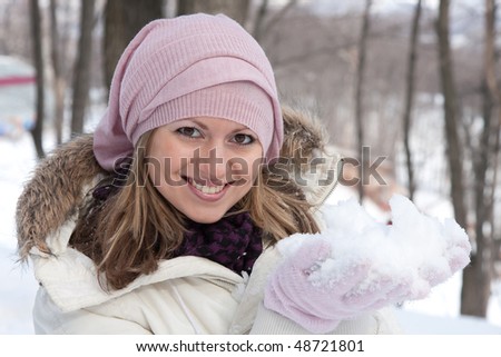 Young girl plays with snow