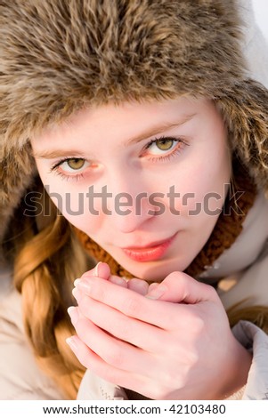 freezing girl warms his hands breath