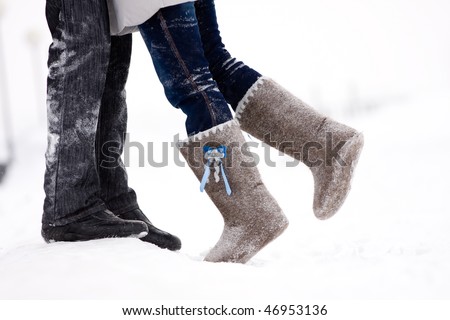 legs embracing couples standing on the snow snowy winter in the middle of the field
