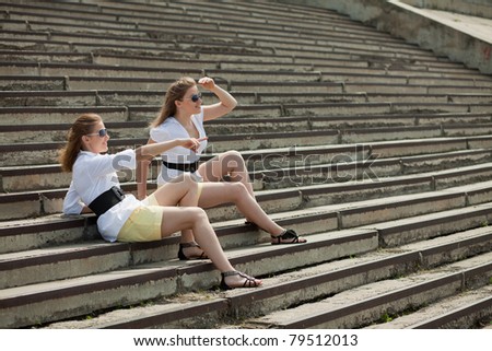 girls are twins on the steps and look into the distance