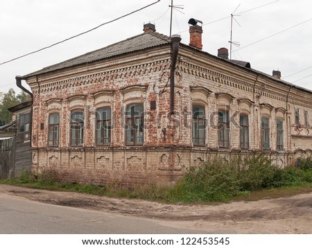 Old brick mansion with road before against cloudy sky background. Gorodets, Nizhegorodsky region, Russia.