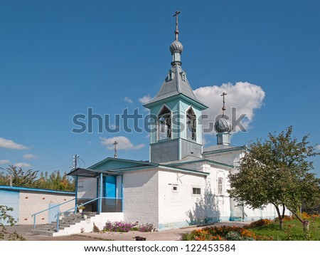 White-stone church of the Falling Asleep of the Mother of God icon with metal fence before against sky background. Semenovo village, Nizhegorodsky region, Russia.
