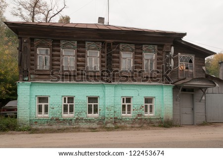 Old two-storeyed brick mansion with road before against cloudy sky background. Gorodets, Nizhegorodsky region, Russia.