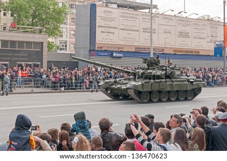 MOSCOW/RUSSIA - MAY 9: People on street side and Russian Army T-90A tank on display during parade festivities devoted to anniversary of Victory Day on May 9, 2011 in Moscow..