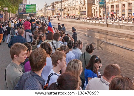MOSCOW/RUSSIA - MAY 9: People on street side wait for motorcade on display during parade festivities devoted to 65th anniversary of Victory Day on May 9, 2010 in Moscow.