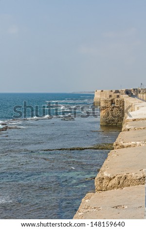 Embankment with sea wall against Mediterranean Sea background. Old city of Acre, Israel.