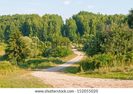 Twisting ascend dirty road in forest on slope. Kaluzhsky region, Russia.