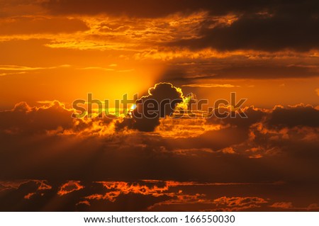 Beautiful sunset with bright Sun behind clouds.