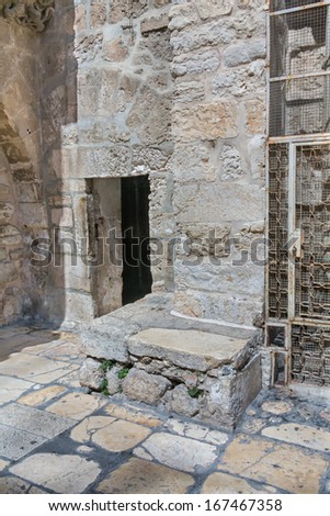 Door in brick stone wall in on courtyard before the Church of the Holy Sepulchre. Jerusalem, Israel.