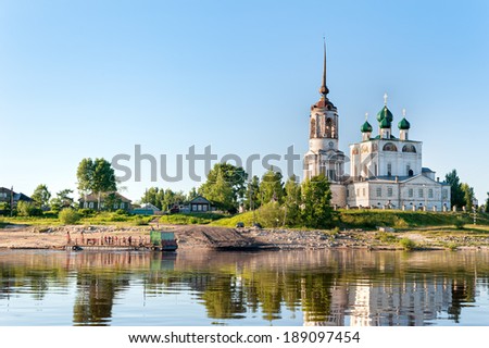 Ancient Annunciation Cathedral (1560-1584) on riverside reflects in water against blue sky background. Solvychegodsk, Arkhangelsky region, Russia.