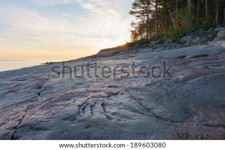 View on Onega Lake granite shore at midnight sun. Besov Nos cape, Karelia Republic, Russia.