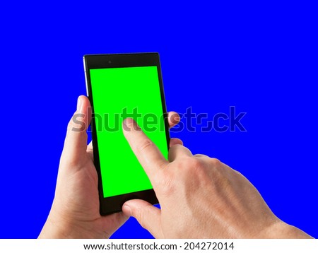 Man holds in hand and tap by index finger tablet PC in portrait mode with green screen isolated on blue. Chroma key screen for placement of your own content.