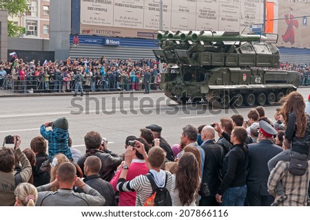 MOSCOW/RUSSIA - MAY 9: People on street and Buk-M2 (SA-11 Gadfly) self-propelled, medium-range surface-to-air missile system on parade festivities devoted to Victory Day on May 9, 2011 in Moscow.
