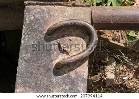 Bent anchoring on metal plate against blurred background