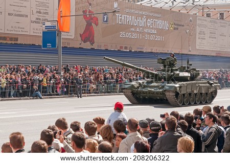 MOSCOW/RUSSIA - MAY 9: People on street side look at Russian Army T-90A tank on display during parade festivities devoted to Victory Day on May 9, 2011 in Moscow..