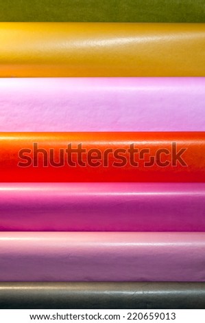 Stand with horizontal multicolor roll of wallpapers