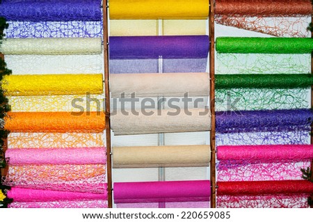 Stand with horizontal multicolor roll of wallpapers