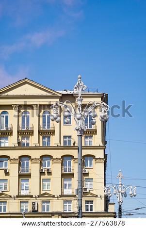 Beautiful old building faÃ?Â§ade with stucco molding and street lamps before against blue sky background. Moscow, Russia.