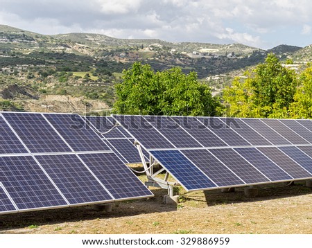 Solar battery stands on hill edge against blurred landscape background. Cyprus.