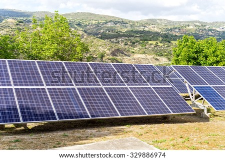 Solar battery stands on hill edge against blurred landscape background. Cyprus.