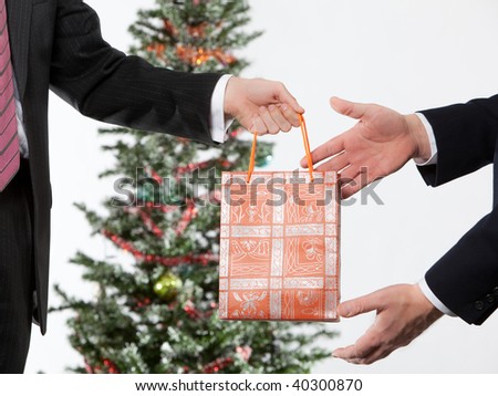 business man giving a christmas gift to a business partner business man giving a christmas gift to a business partner