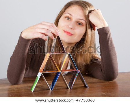 young woman building  credit card pyramid