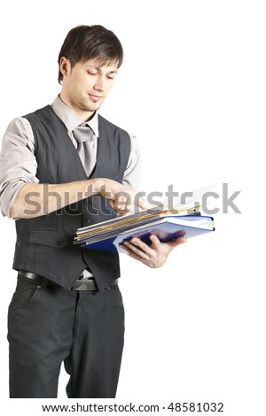 A handsome young businessman with vest and rolled-up sleeves stands and reads a stack of files. Vertical shot. Isolated on white.