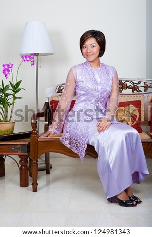Beautiful young Malay woman in pink baju kurung, a traditional costume.