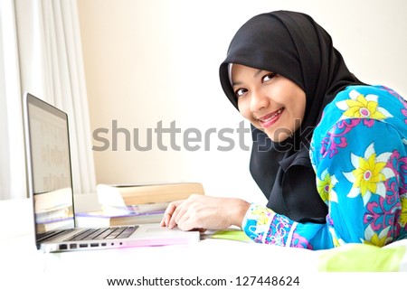 Young Muslim female student with laptop