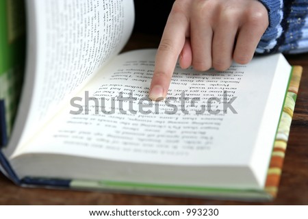 Reading : Index finger pointing on a paragraph of a book