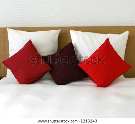 Reserve just for you : Concept of isolation, relaxation to unwind and be alone. Five fluffy cushions on a beautifully made bed.