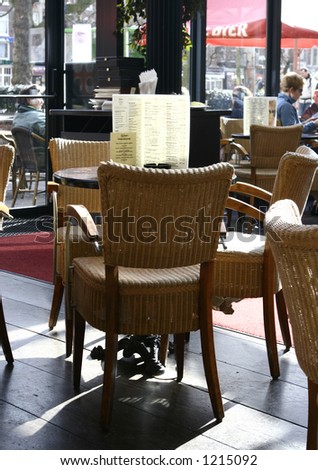 A table for three: Three wicker chair around a circular table in a restaurant on a warm day