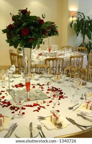  setting showing tables and chairs with cutlery and tall red rose