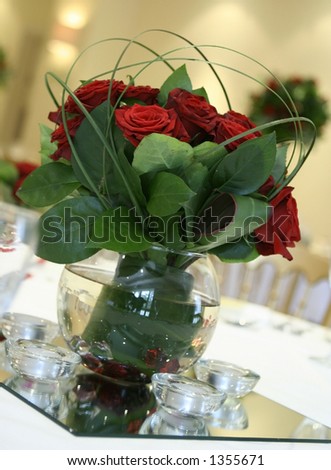 stock photo A pretty table centerpiece made out of red roses and bear 