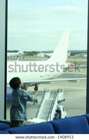 I\'d like to fly like a plane. A little boy stands in awe at the sight of plane parked outside the viewing gallery