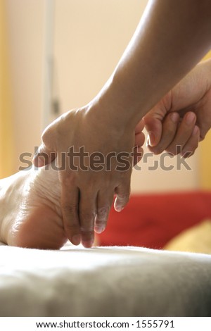 A woman receiving a foot reflexology as part of a holistic massage treatment