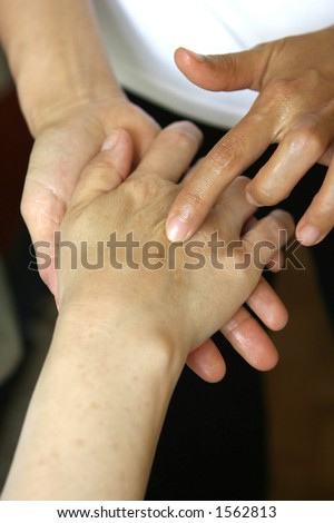 A massage therapist giving a hand massage to a client