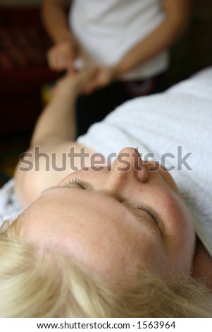 A lady receiving a hand massage as part of a holistic massage treatment