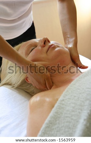 A lady receiving a head massage as part of a holistic massage treatment