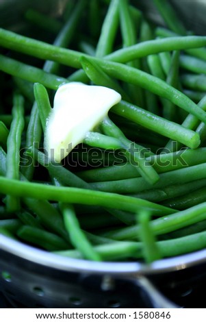 Close up of steamed fine beans with a knob of melted butter