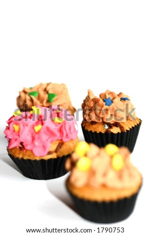 Four colorful mini cupcakes, isolated on white with copy space