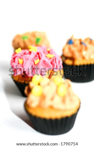 Four colorful mini cupcakes, isolated on white with copy space