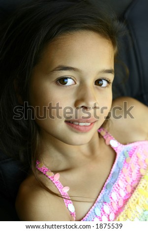 A girl with pretty brown eyes smiles as she relaxes in a comfort seat