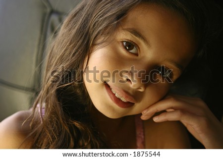 A girl smiles happily in the warm glow of the evening sun