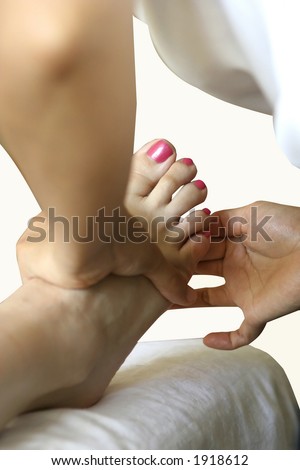 A lady receiving foot reflexology as part of a holistic body massage treatment.