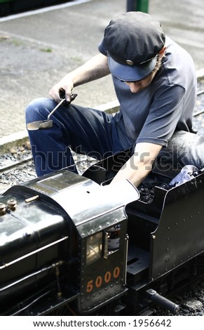 A young attendant tending the model steam train just before it leaves the station.
