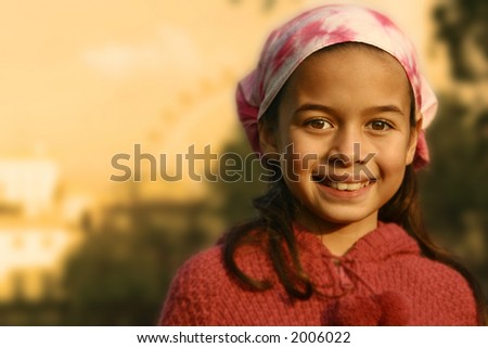 A young girl with pink bandanna showered by the glow of the evening sun
