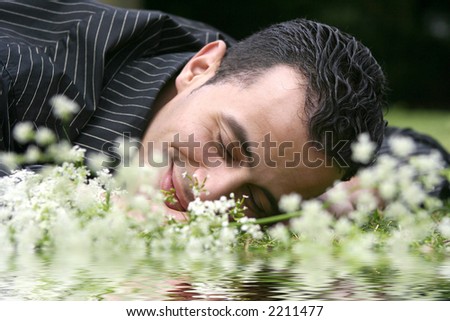 A young man dreaming by the lake with reflection
