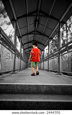 A young boy walking towards the end of an overhead bridge. Rendered in colour with black and white surrounding. Concept of fear and loneliness.